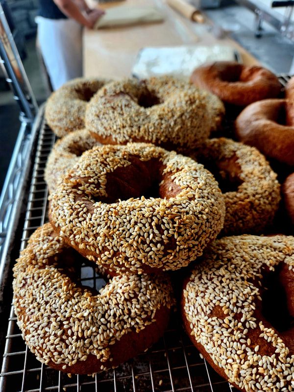 Freshly baked sesame bagels cooling on a wire rack in the Harvest Moon bakery